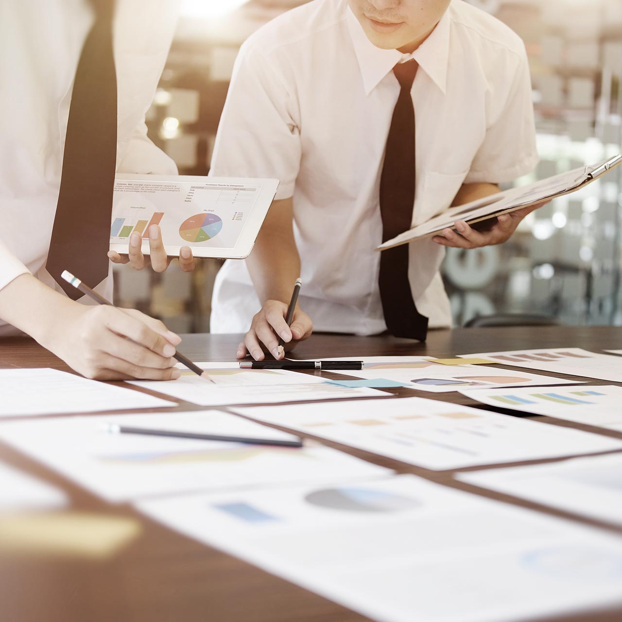 Businessmänner mit Tablet schauen Analysereports an